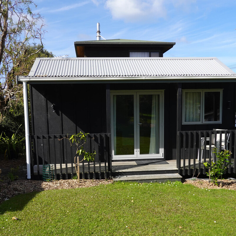 The cottage has a covered verandah facing the sunset